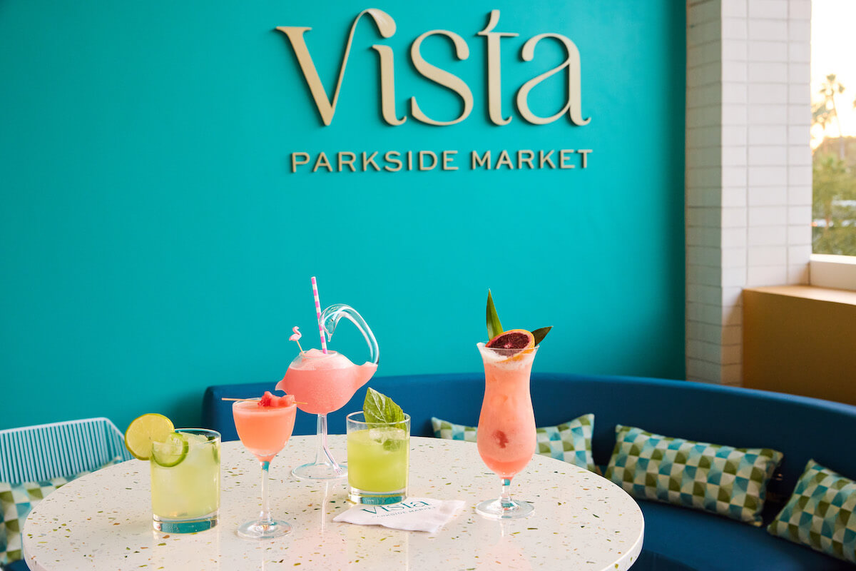 collection of cocktails on a table in front of a sign that says vista parkside market